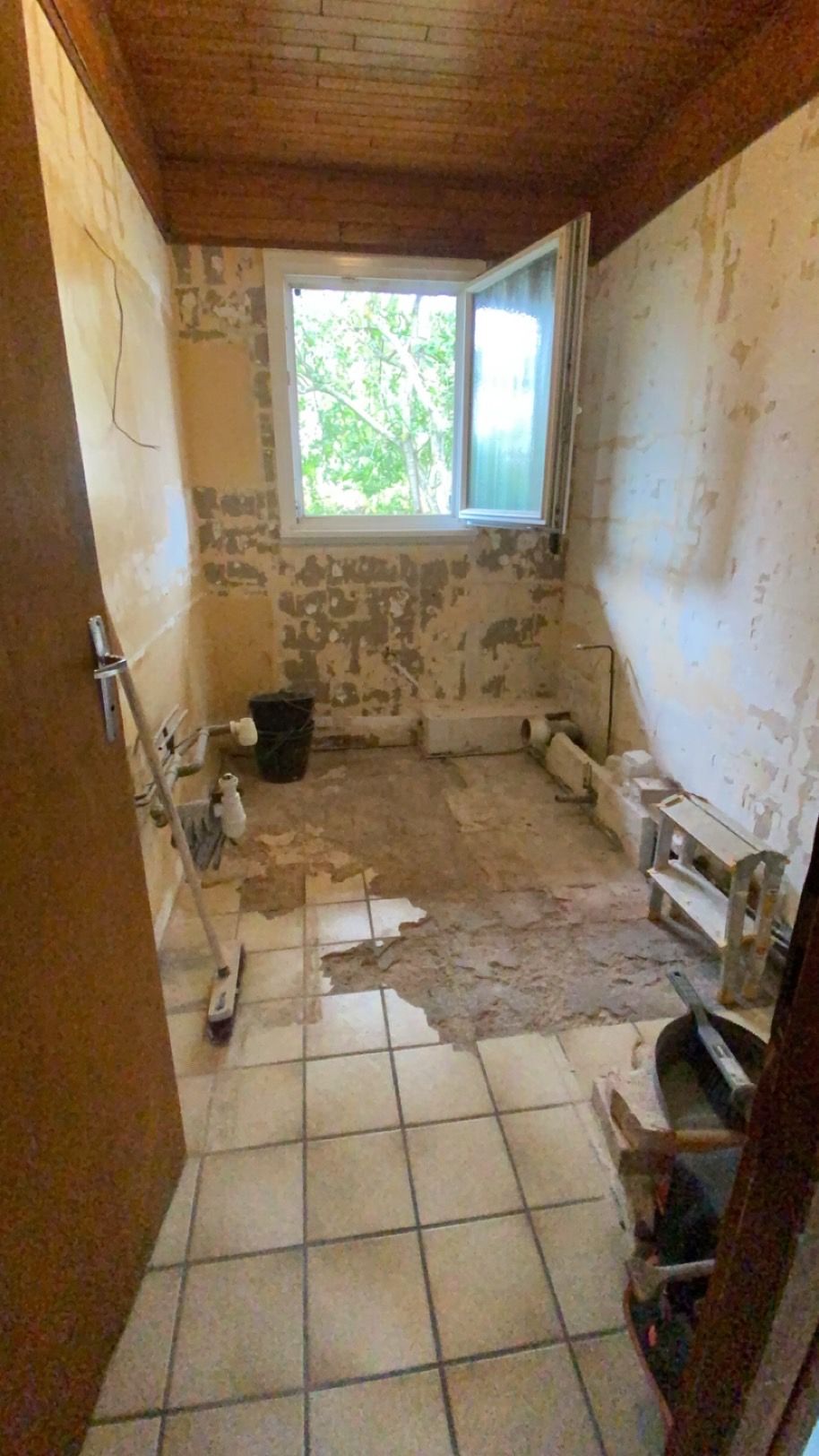 Salle de bain entièrement dépouillée avec murs nus et plomberie apparente